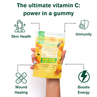Vegums wholefruit vitamin c gummies packet hand holding the packet with the key points of the vitamin pointed out like immunity, skin health and energy boost