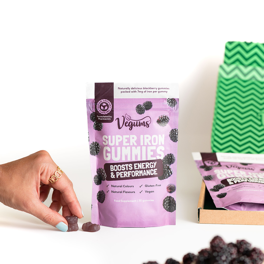 vegums super iron vegan gummy vitamins UK hand holding gummy bear vitamin and eco packet