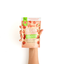 Hand holding a vegan multivitamin package with a white background