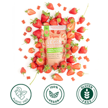 Vegan multivitamin package surrounded by strawberries with '100% Vegan', 'Plastic Free', and 'Gluten Free' labels.
