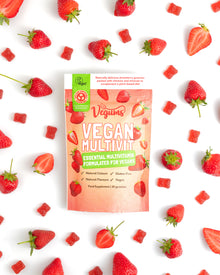 Vegums Vegan Multivitamins package surrounded by strawberries on a white background