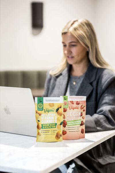 Vegan Pregnancy Bundle supplements on desk with woman